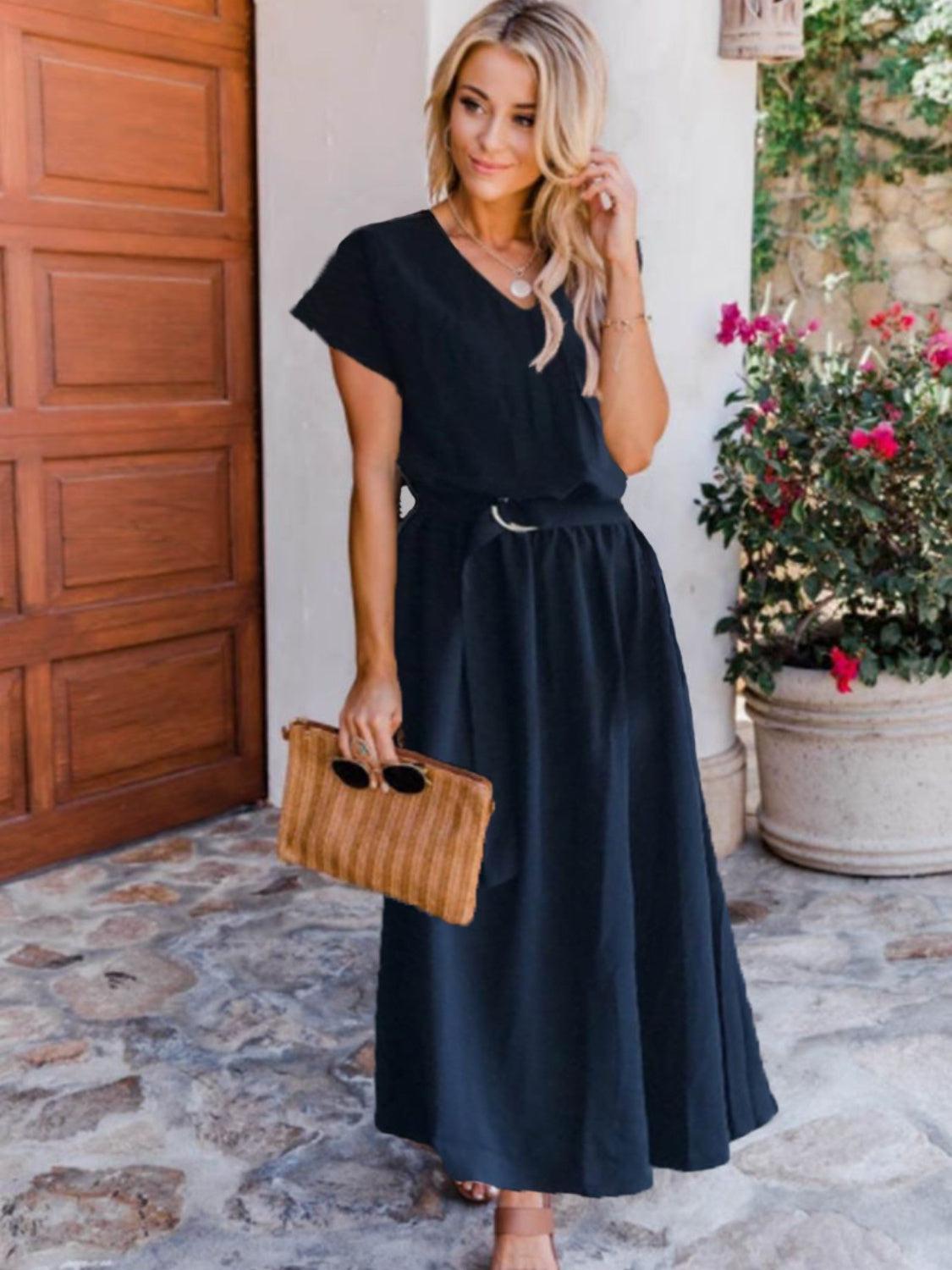 a woman wearing a black dress and a straw bag