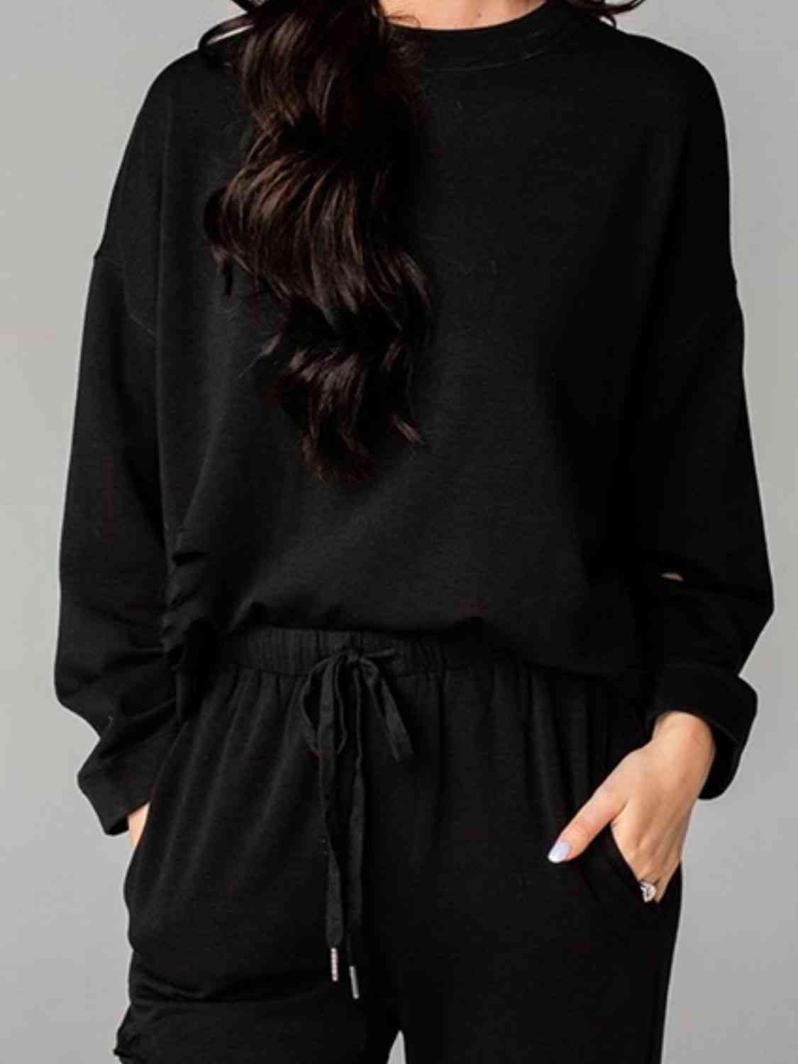 a woman wearing a black sweatshirt and sweatpants