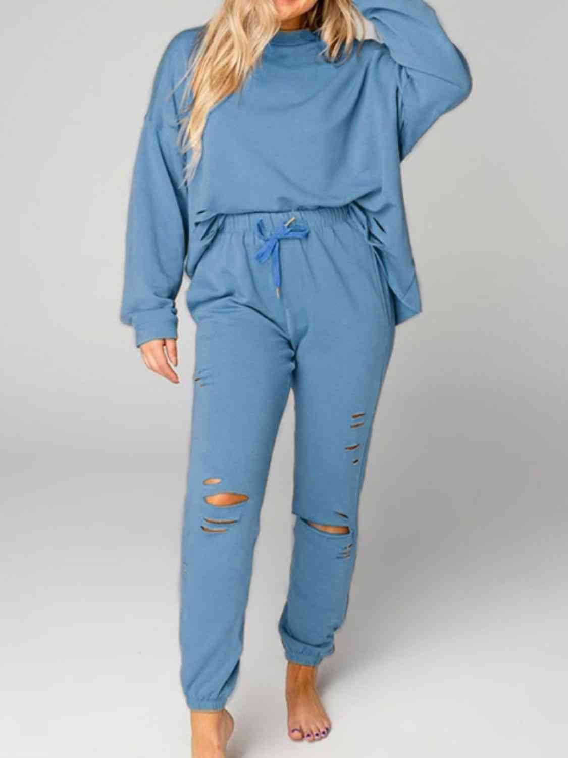 a woman wearing a blue jumpsuit with ripped knees