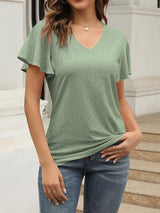 a woman wearing a green top and jeans