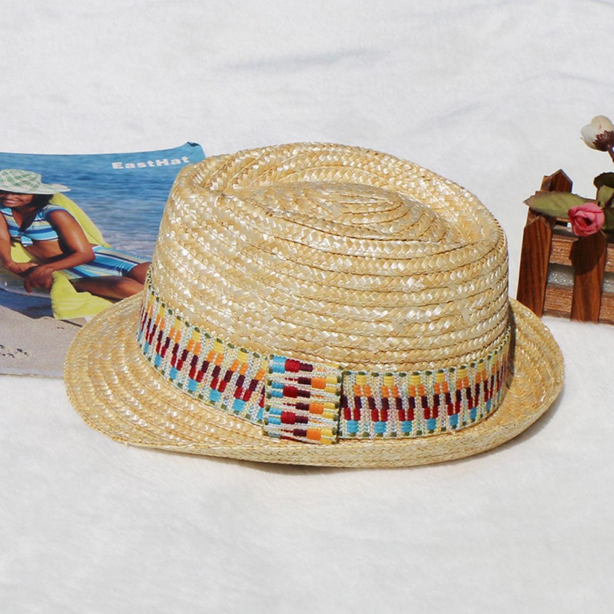 a straw hat sitting on top of a table next to a magazine