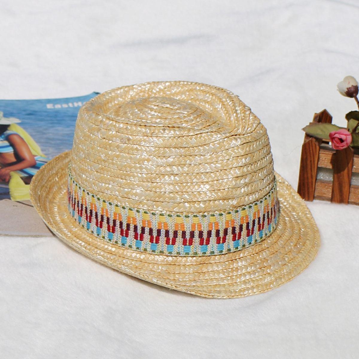 a straw hat sitting on top of a white blanket