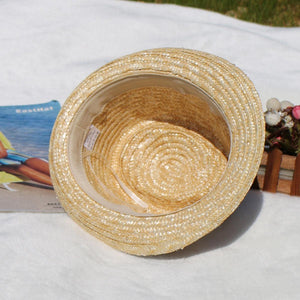 a straw hat sitting on top of a white blanket