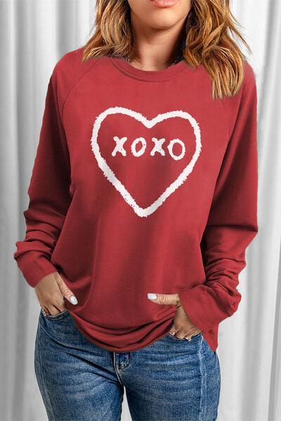 a woman wearing a red sweatshirt with a heart and xoxo written on it