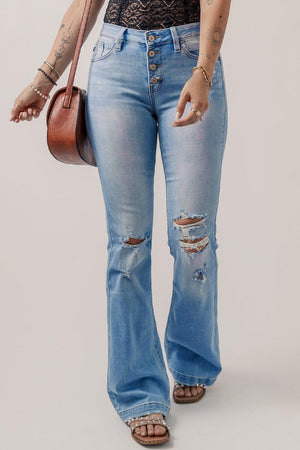 a woman in a black top and jeans holding a purse