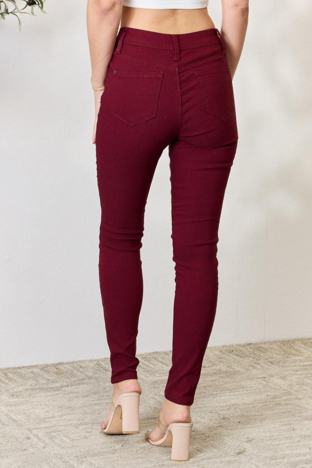 a woman in a white top and maroon pants