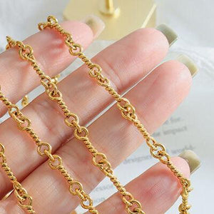 a woman's hand holding a gold chain