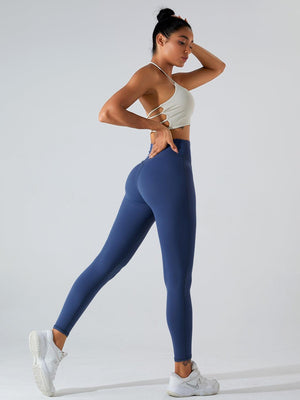 a woman in a white top and blue leggings