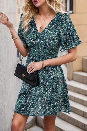 a woman in a green dress is walking down the street