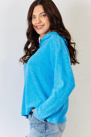 a woman in a blue sweater posing for a picture