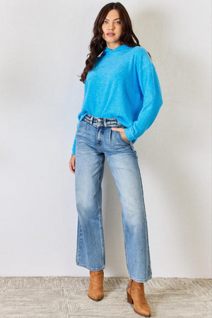 a woman wearing a blue sweater and jeans