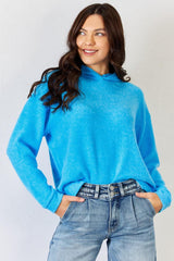 a woman wearing a blue sweater and jeans