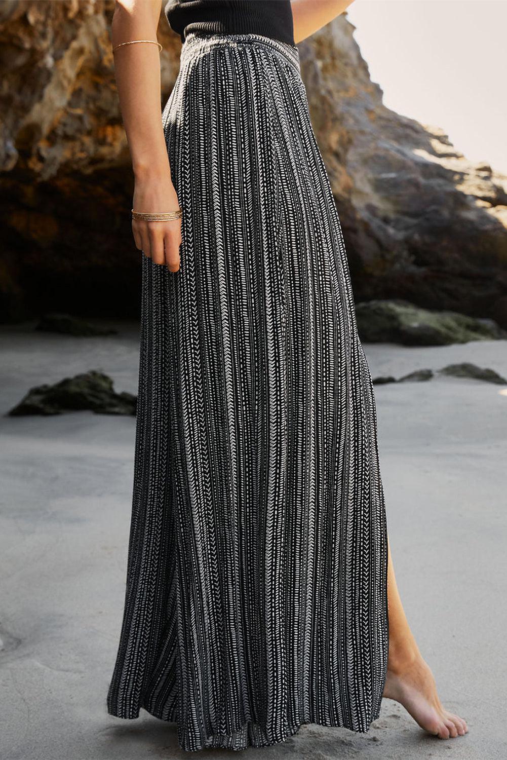 a woman standing on a beach wearing a black and white dress