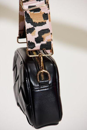 a black purse with a pink and black leopard print strap