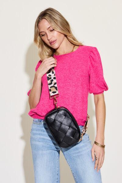 a woman in a pink top is holding a black purse