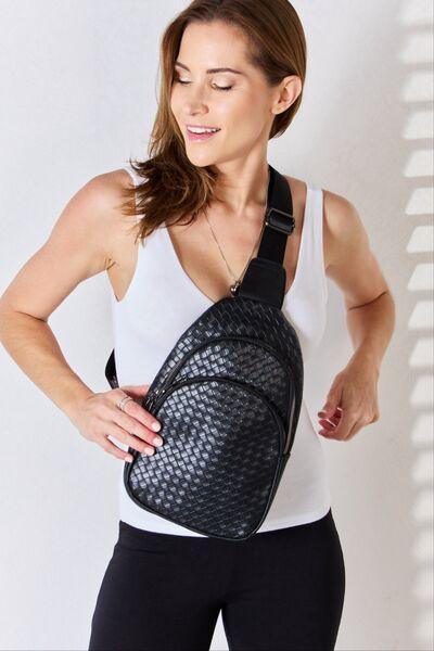 a woman is holding a black fanny bag