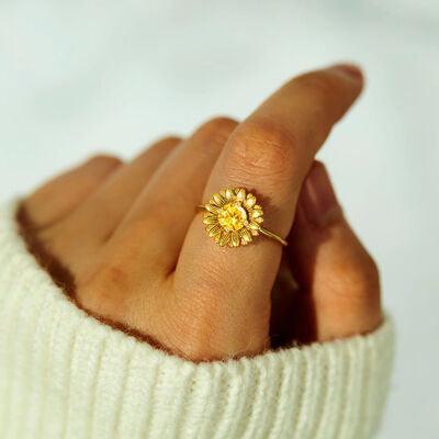 a woman's hand with a yellow flower ring on it