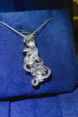 a silver necklace with a lizard on it