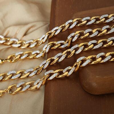 a gold and silver chain on a wooden surface