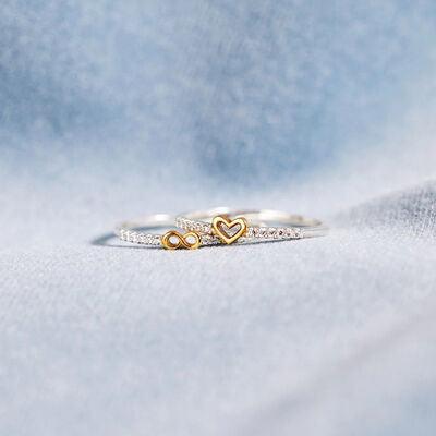 a heart shaped ring sitting on top of a white cloth