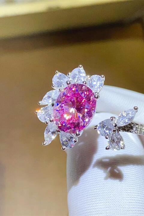 a pink diamond ring sitting on top of a white napkin