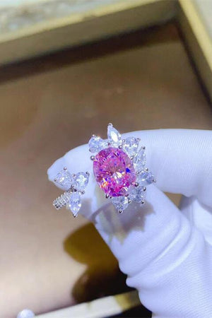 a person wearing a ring with a pink diamond