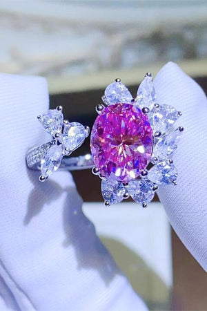 a pink diamond ring sitting on top of a white napkin