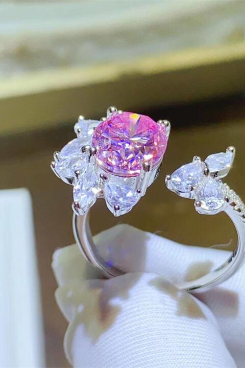 a pink diamond ring sitting on top of a white napkin