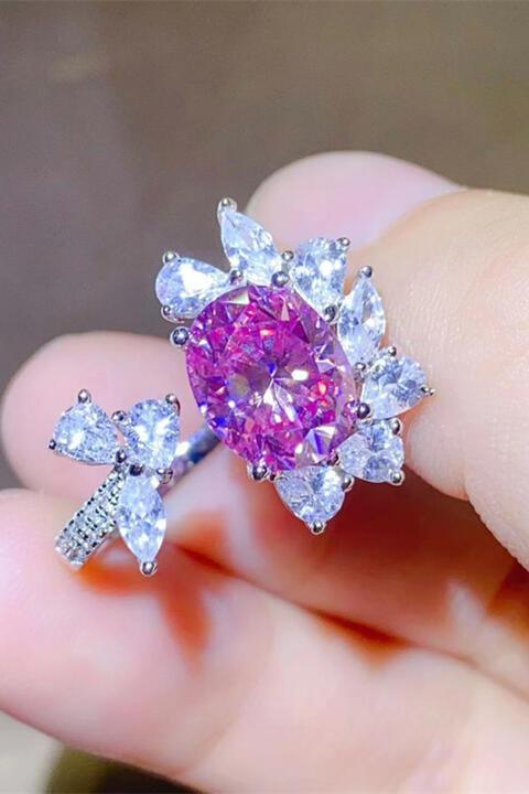 a person holding a pink and white diamond ring