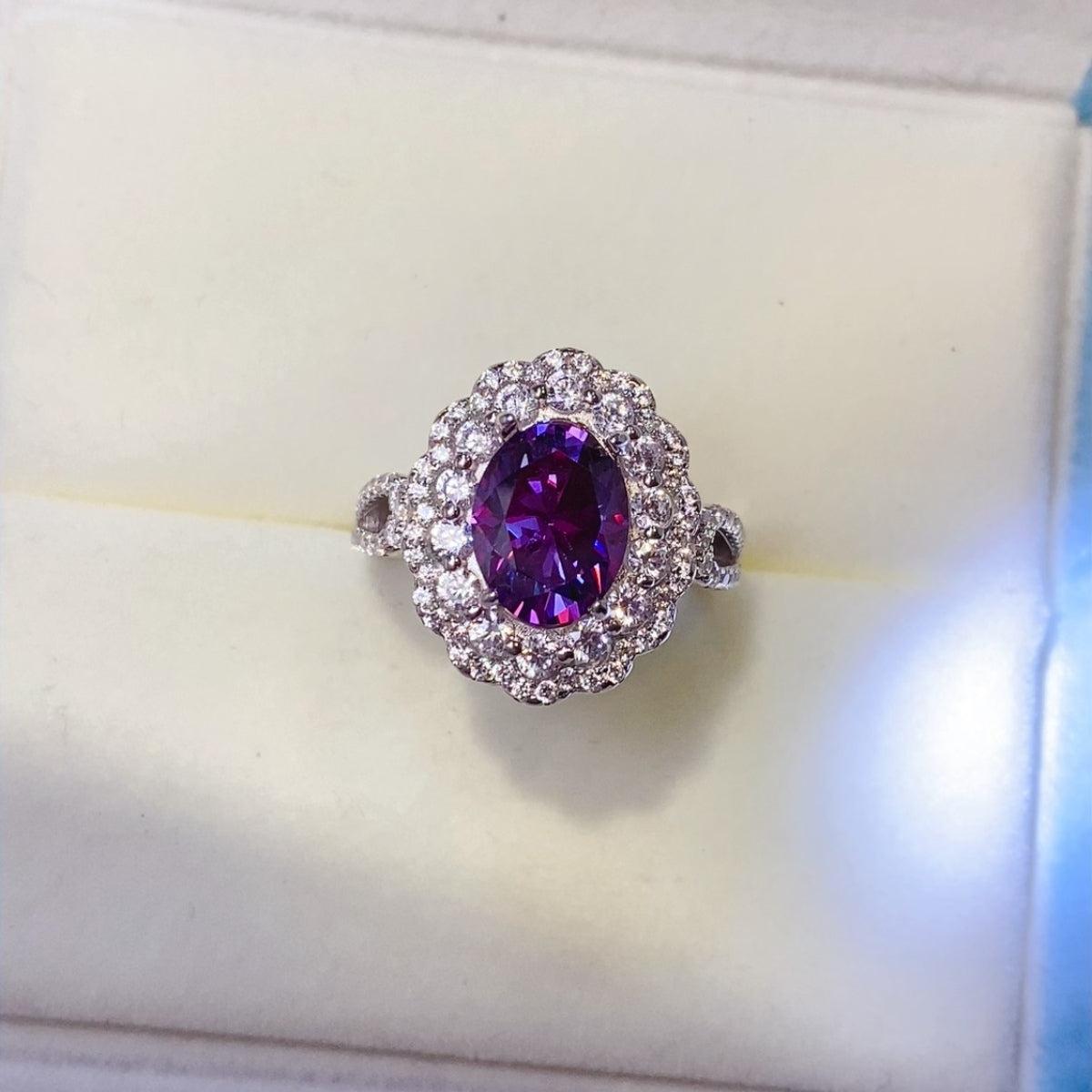 a ring with a purple stone surrounded by diamonds