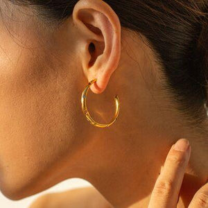 a close up of a person wearing a pair of earrings