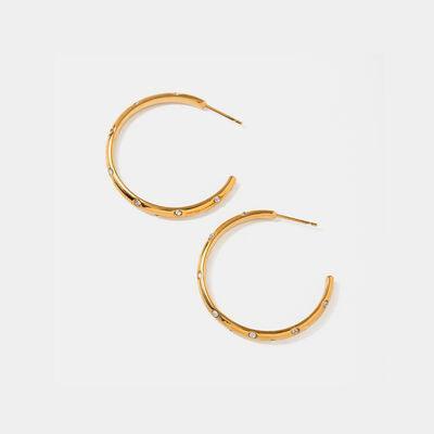 a pair of gold hoop earrings on a white background