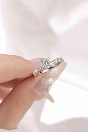 a woman's hand holding a diamond ring