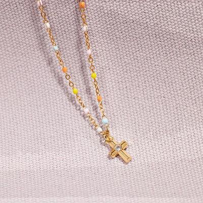 a gold cross necklace with multi colored beads