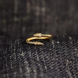 a pair of gold rings sitting on top of a piece of cloth