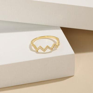 a gold ring sitting on top of a white box