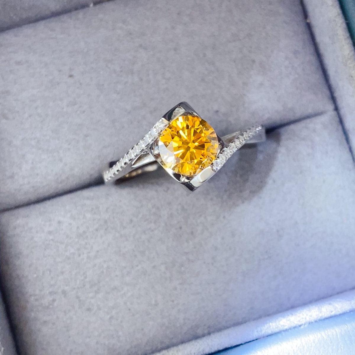 a fancy yellow diamond ring in a box