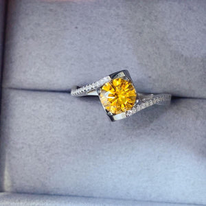 a yellow diamond ring sitting on top of a box