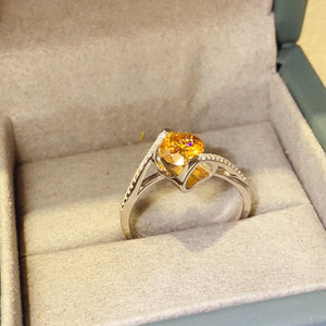 a yellow diamond ring in a box on a table