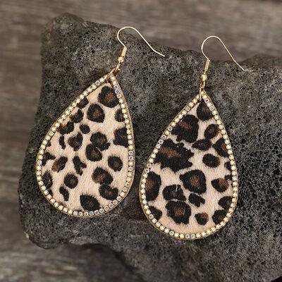 a pair of leopard print earrings on a rock