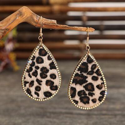 a pair of leopard print earrings hanging from a branch