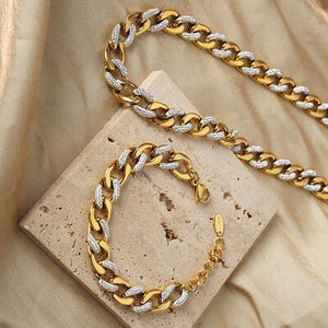 a gold and silver chain on a marble block