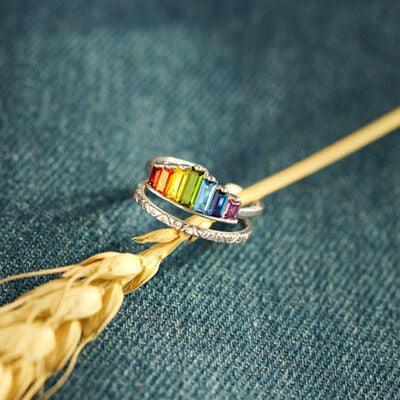 a rainbow colored ring sitting on top of a blue piece of cloth