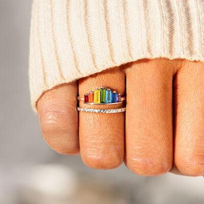 a woman's hand with a rainbow ring on it