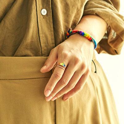 a woman wearing a colorful bracelet and a ring