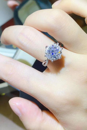 a close up of a person's hand holding a ring