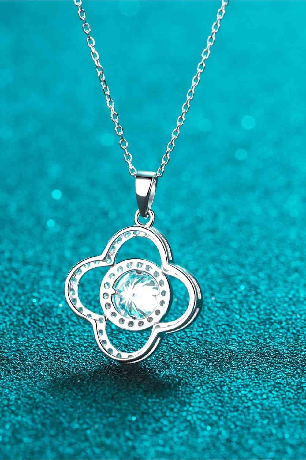 a necklace with a flower design on a blue background