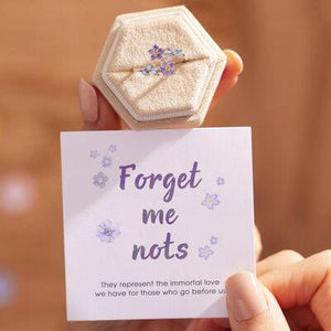 a person holding a card that says forget me nots