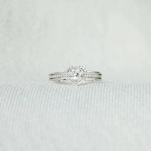 a close up of a diamond ring on a white cloth