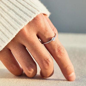 a woman's hand with a diamond ring on it